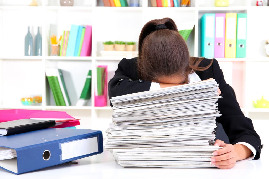 Tired woman with documents in her workplace