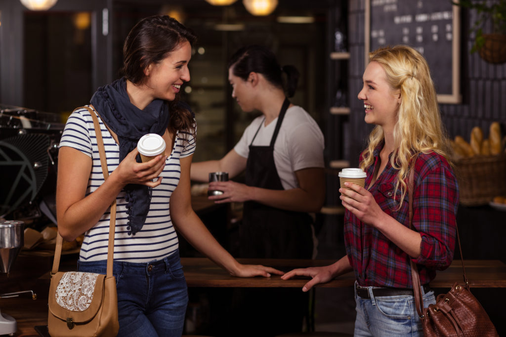 Smiling friends enjoying coffee at the coffee shop